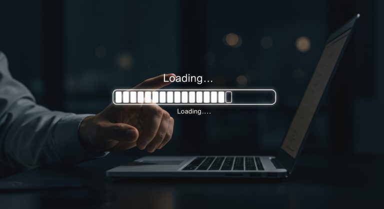 Person pointing at laptop screen with loading progress bar in dark office background showcasing low speed.