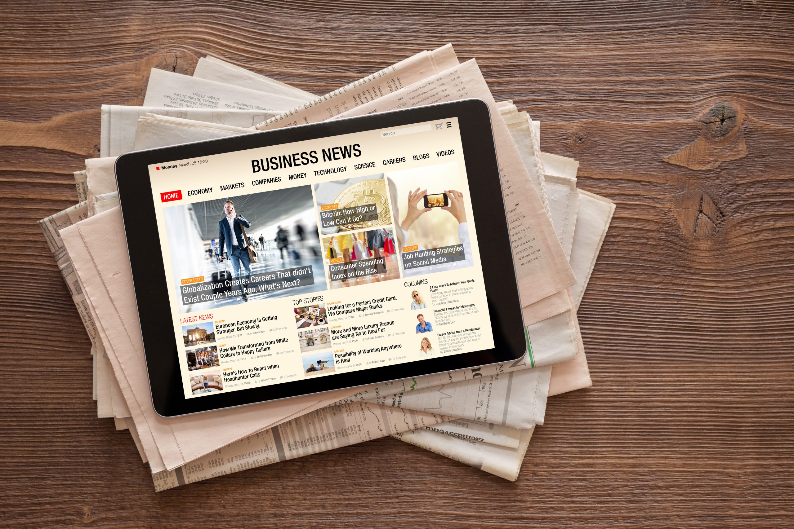 A top-down view of a digital tablet resting on a messy stack of traditional printed newspapers on a wooden table. The tablet screen displays a "BUSINESS NEWS" website with articles about globalization, Bitcoin, and job hunting strategies, symbolizing the shift from print to digital media.